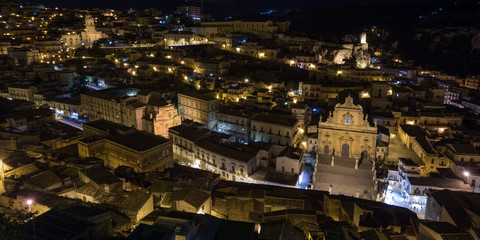 Fototapeta na wymiar Night view of Modica and the illuminated San Pietro church 