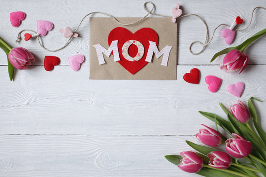 Background for congratulations for Mother's Day with greeting card, hearts and pink tulips