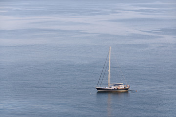 People rest on a yacht and swim in the sea, view from far away