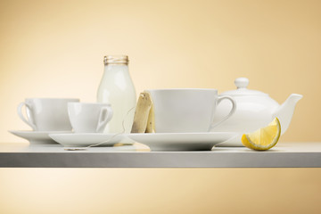 cup of tea on white table with teabag and lemon slice