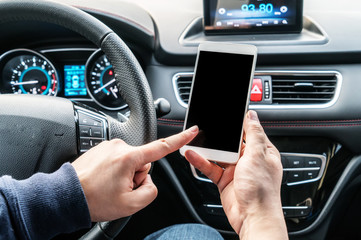 Shot of a handsome man using mobile phone while driving.