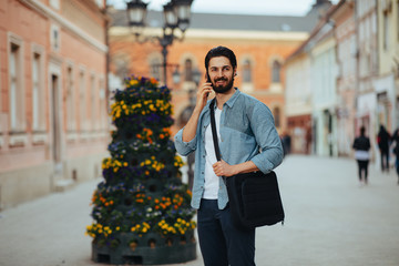 Handsome businessman talking on the phone on the street