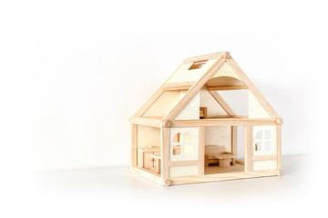 Wooden house model with furniture on white surface. Facade view. Isolated on white. Real estate....