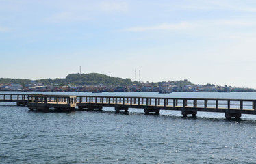 Fototapeta na wymiar Walkway cement bridge over the sea and shore background