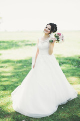 Fototapeta na wymiar Beautiful bride posing in wedding dress outdoors