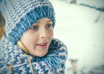 Head of a girl in a knitted hat in winter.