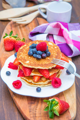 dish with pancakes and strawberry,raspberry and blueberry and chocolate 