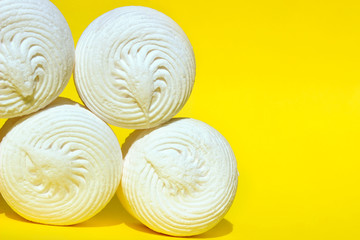Fototapeta na wymiar Images Of Five Sweet Round Shaped Marshmallows On Yellow Background. White Marshmallows on Yellow Background. 