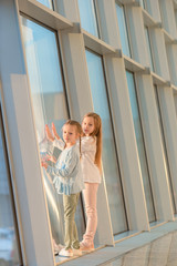 Little adorable girls in airport near big window