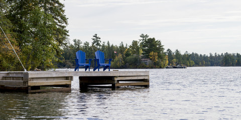 Naklejka premium Adirondack chairs on a dock, Kenora, Lake of The Woods, Ontario, Canada