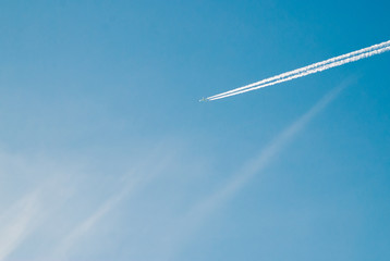 Long trace of the aircraft in the blue sky,