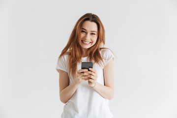 Fototapeta premium Portrait of a happy young girl holding mobile phone