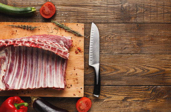 Raw rack of lamb on wooden board