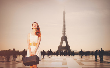 Fototapeta na wymiar Beautiful redhead woman from province has come to conquer Paris. Eiffel tower on background