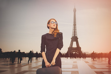 Fototapeta na wymiar Beautiful redhead woman from province has come to conquer Paris. Eiffel tower on background