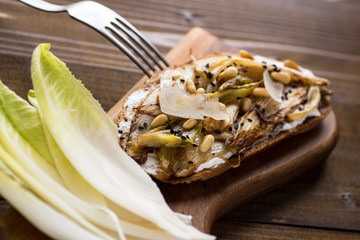 Roast Organic Chicory on Bread Slice with Pine Nuts and Black Sesame. Organic Healthy Food.