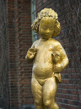 Close-up of golden statue of girl with flower, Stockholm, Sweden