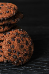 oatmeal cookies with chocolate on a dark wooden background