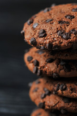 oatmeal cookies with chocolate on a dark wooden background