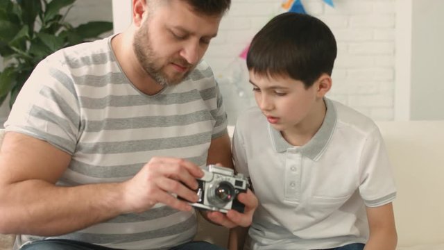 Dad shows his son a camera device