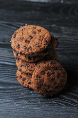 oatmeal cookies with chocolate on a dark wooden background