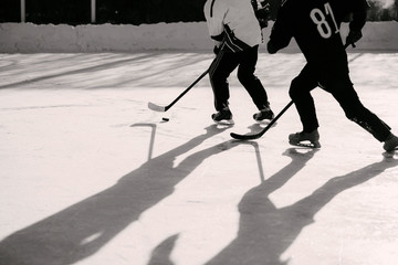 Naklejka premium men play hockey on the rink during the day