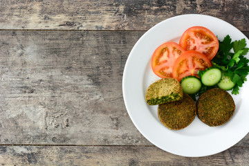Grilled veggie hamburger with spinach and peas on wooden table. Top view. Copyspace