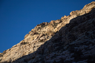 Escarpment with blue sky and shadow, Nevada, USA.
