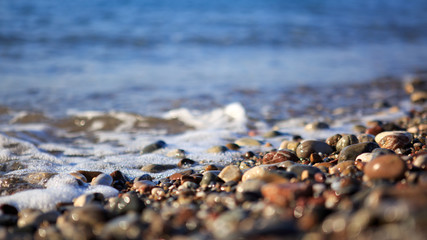 Waves washing over gravel beach, macro shot.