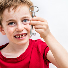 happy growing up boy showing key for fun tooth fairy