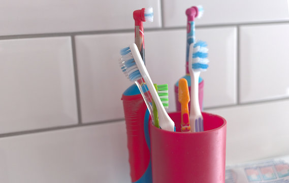 A variety of toothbrushes, including electric toothbrushes in a bathroom setting
