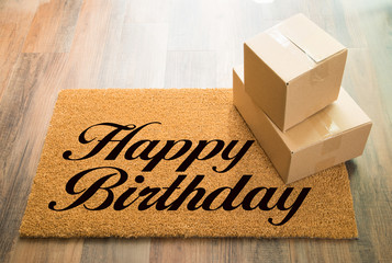Happy Birthday Welcome Mat On Wood Floor With Shipment of Boxes