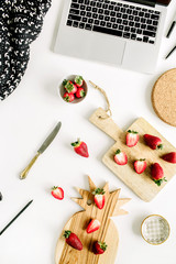 Strawberries on home office desk with laptop. Flat lay, top view.