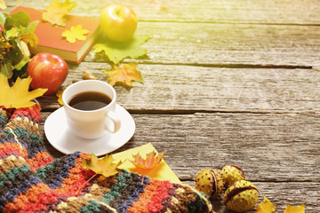 Frame of autumn red, green and yellow leaves, apples with cup of coffee or tea with books on vintage background.