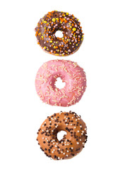 Three colorful glazed donuts isolated on white background, top view