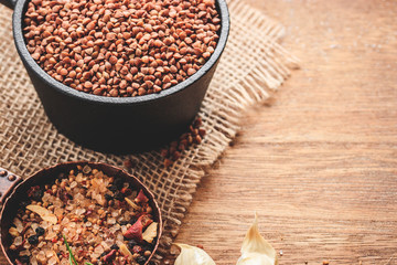 Buckwheat with spices on natural wooden background