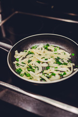 frying pan with sauteed onions and shallot being cooked