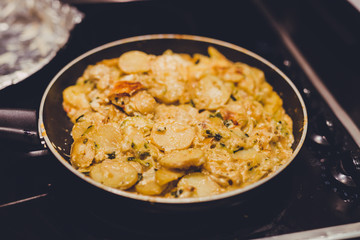 frying pan with potatoes, onions and zcchini recipe being cooked