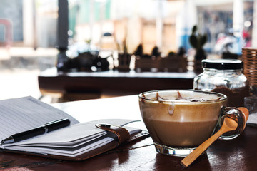 Pen and notebook on coffee table in coffee shop