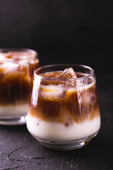 Iced coffee in glasses with milk. Black background