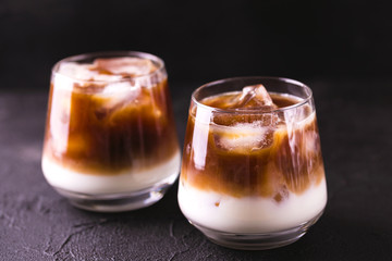 Iced coffee in glasses with milk. Black background