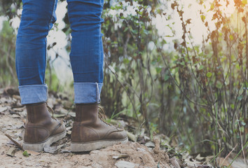 Hipster feet a man and jeans sneaker in nature and relax time on holiday. selective and soft focus color of vintage tone
