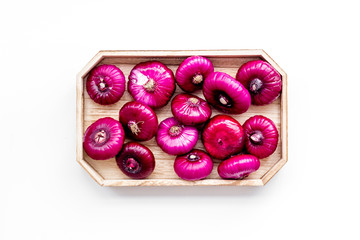 Red onion is healthy product. Onion bulbs in tray on white background top view