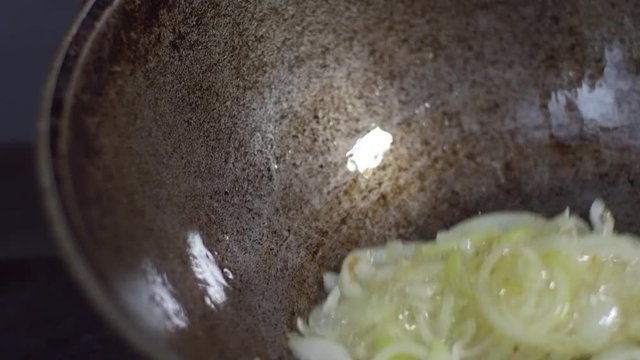 Cook shaking frying pan when preparing chopped onions for pilaf, close up shot of frying pan