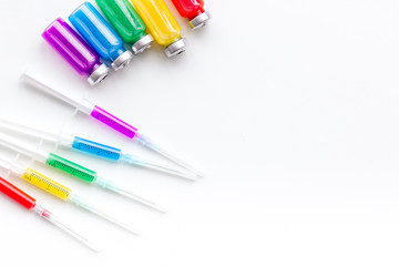 Syringe with colored drug. Injection concept on white background top view copy space