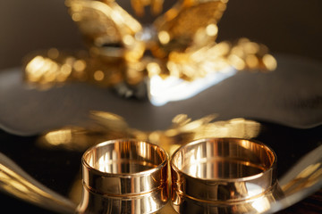 gold wedding rings on gold plate with swans