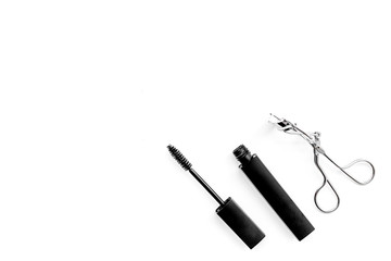 Basic products for eyelashes makeup. Mascara and eyelash curler on white background top view copy space
