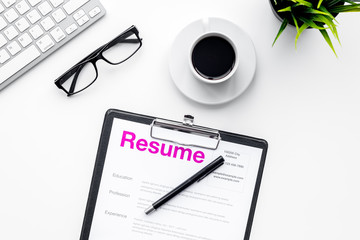 Create resume. Resume on white work desk with coffee, glasses, keyboard top view