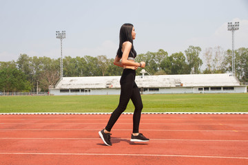 Obraz premium Asian lady running in track stadium