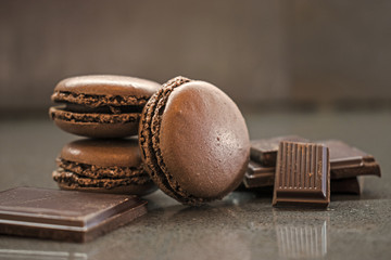 chocolate or coffee taste french macaroons on dark background, selective focus, crushed chocolate